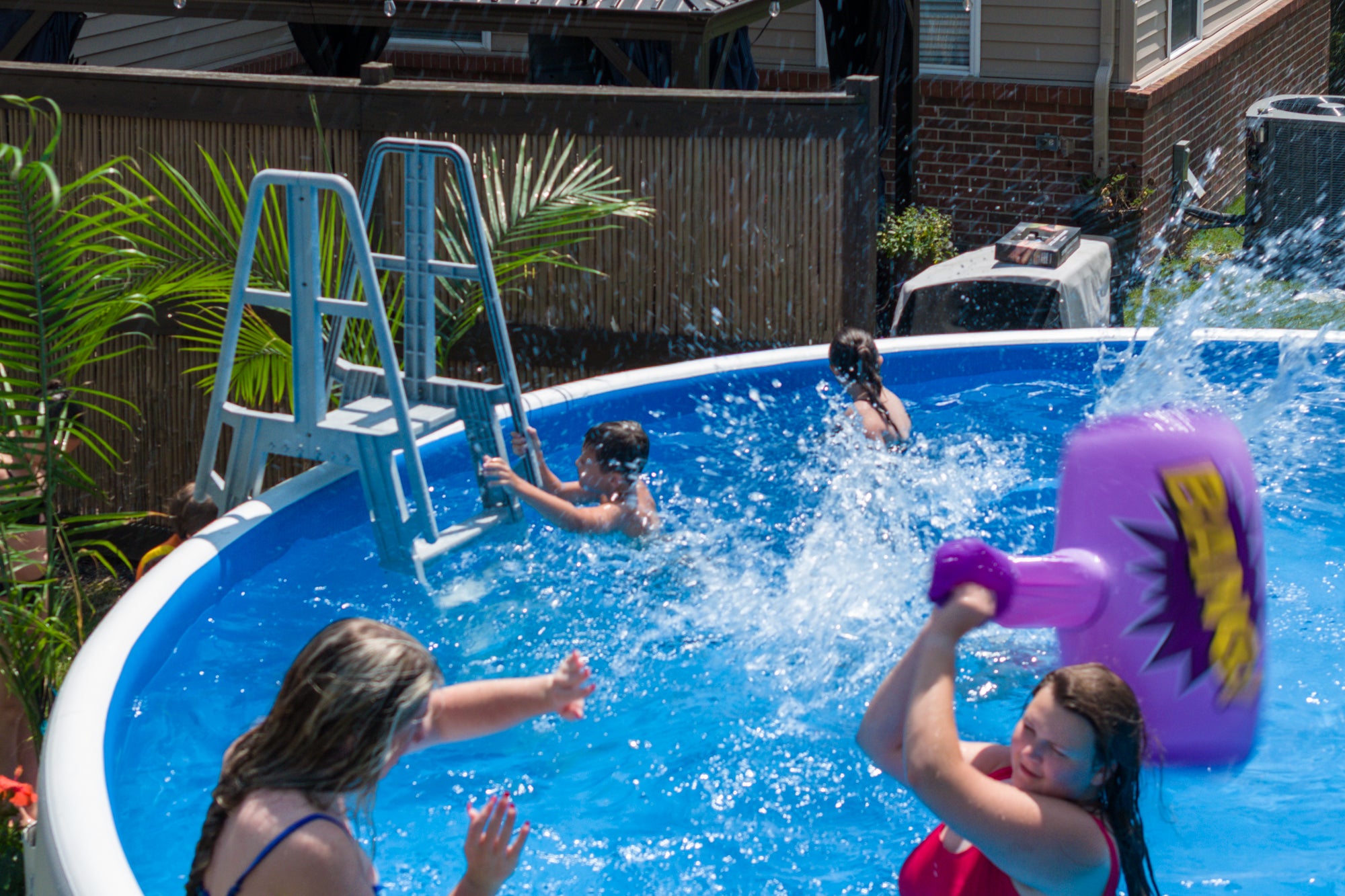 Family splashing and playing in a Perfect Pool fitted with a ladder, highlighting the pool’s 90‑minute quick setup time