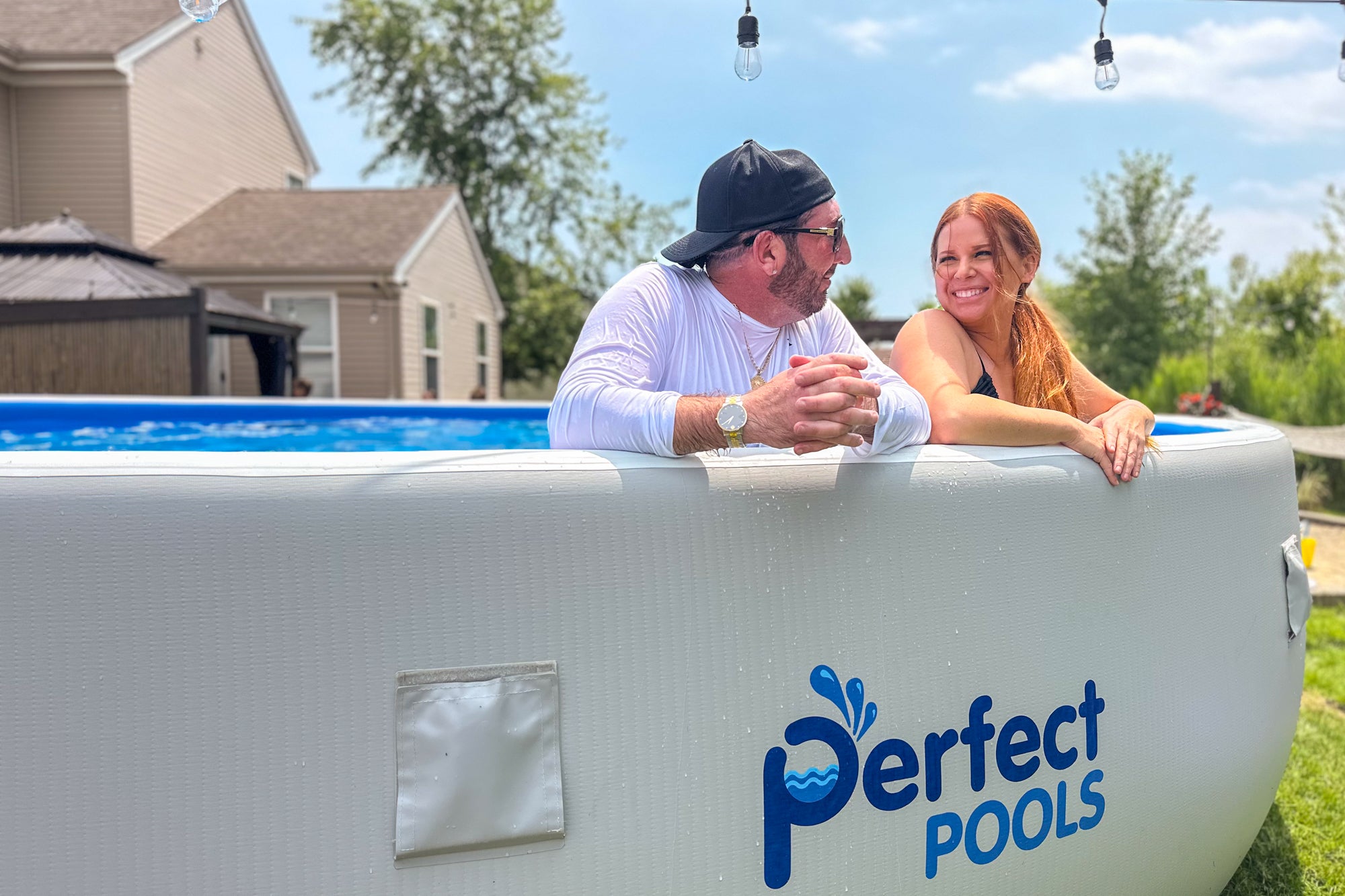 Couple relaxing in a Perfect Pool portable above‑ground pool, emphasizing that no permits are required in most areas for temporary pools