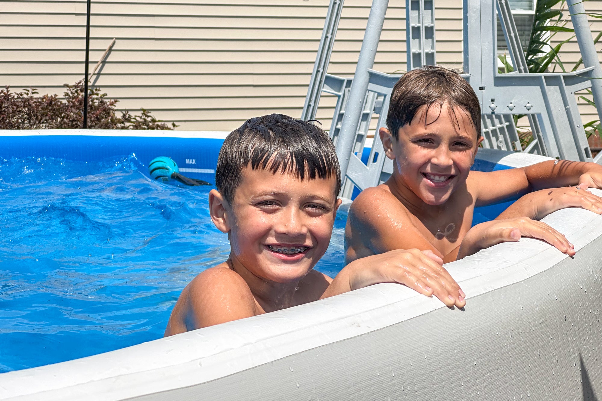 Two young boys leaning on the edge of a Perfect Pool near a ladder, demonstrating how children can easily enjoy the pool after quick setup